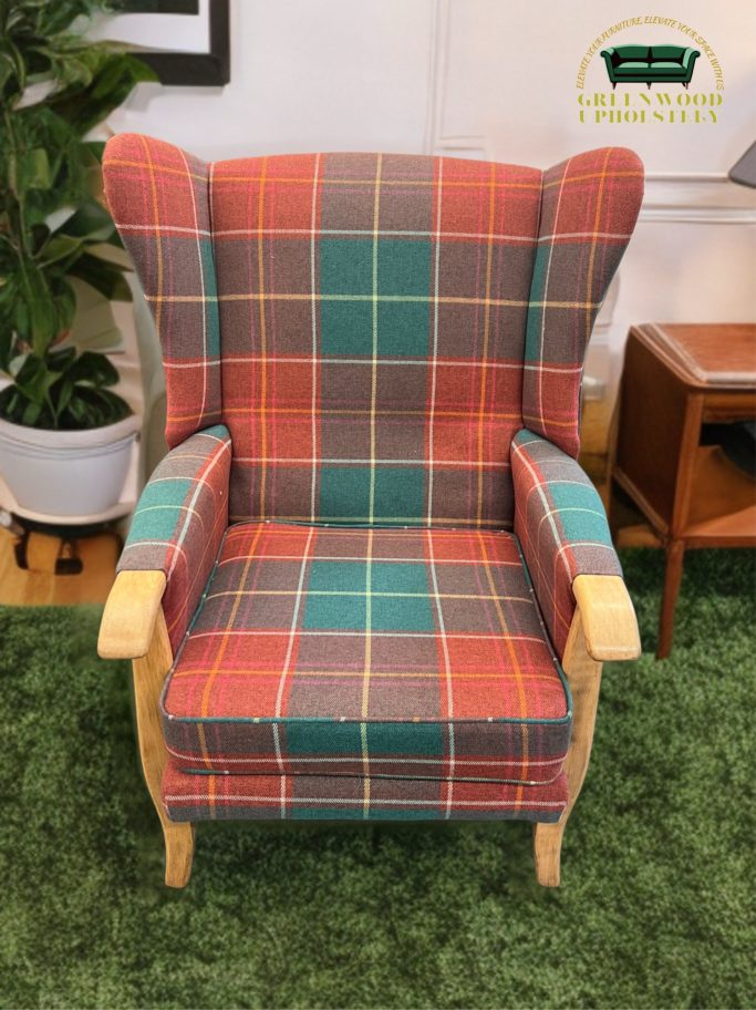 Plaid-patterned armchair with wooden arms and a green carpet background.