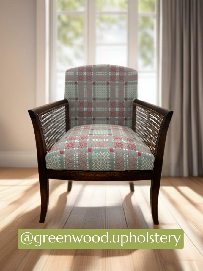 A wooden chair with a patterned cushion and backrest, positioned in a bright room.