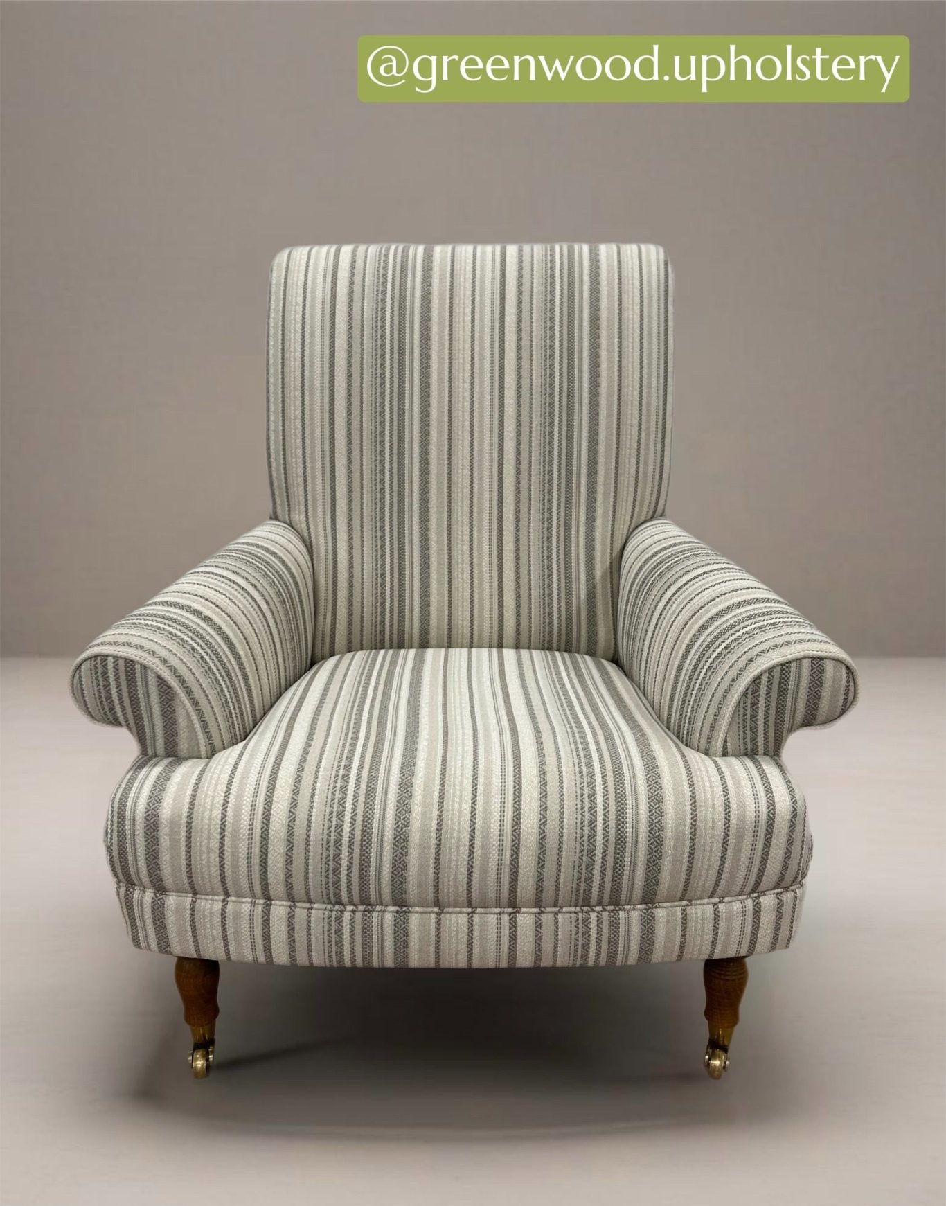 Striped armchair with wooden legs, upholstered in soft fabric.